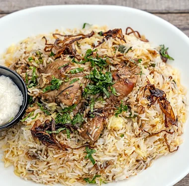 Malabar Dum Biryani topped with fried onions and herbs